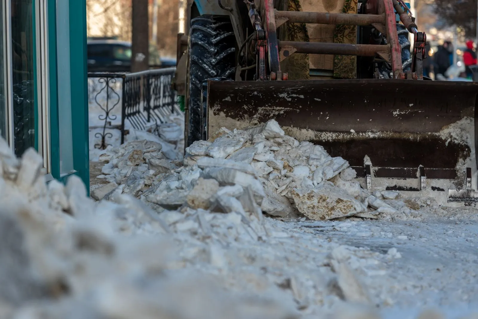 A snow plow clearing accumulated snow from an urban street during winter.